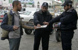 A Palestinian man offers sweets to Hamas