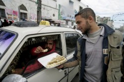 A Palestinian man distributes sweets in