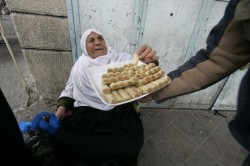 A Palestinian man offers sweets to a wom